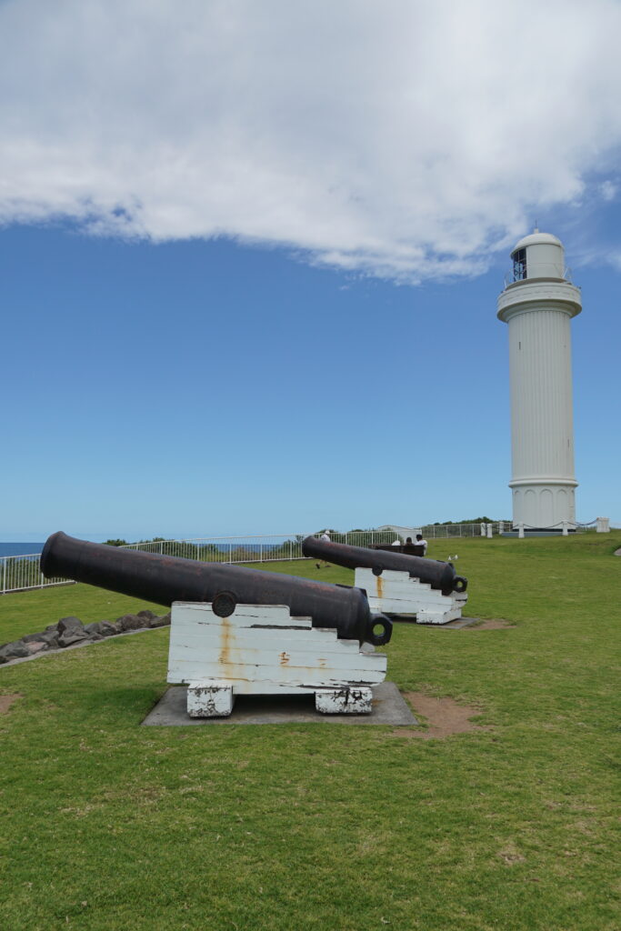 Wollongong Head Lighthouse, with two cannons in the foreground.