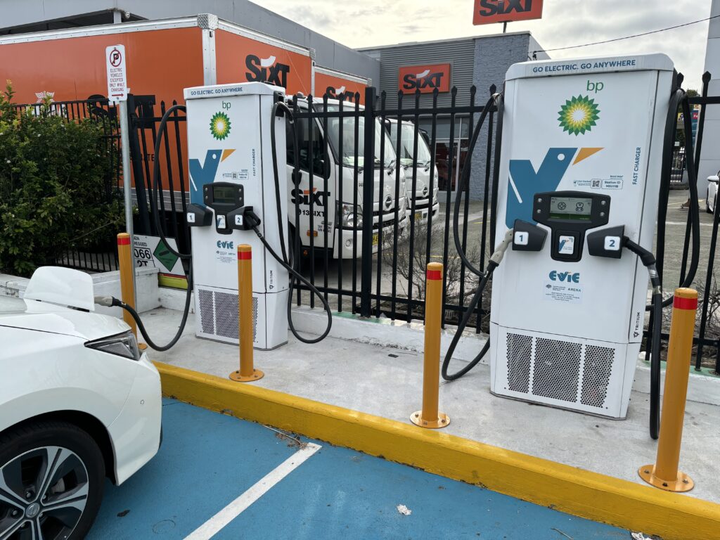 Two electric vehicle chargers, with one in use connected to a Nissan Leaf slightly out of shot.