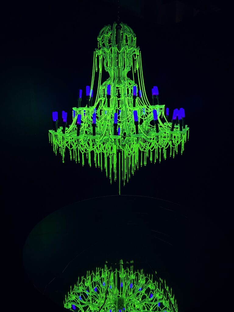 Uranium glass chandelier undergoing fluorescence via UV lights.