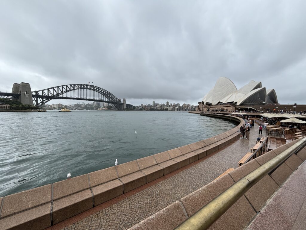 Wide shot of the Sydney Harbour Bridge on left, and the Sydney Opera House.