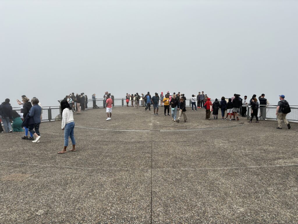 A viewing platform in Katoomba with numerous visitors, but with a complete whiteout situation in fog.